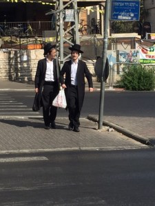 Walking home you can see these two men have a tall plastic bag between them, that holds the lulav.