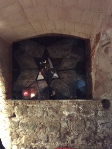 A stained glass window delineating the women's section of the synagogue. There is a solid wall behind the window as another building was erected there after the synagogue was abandoned. Perhaps one day it will be excavated.