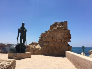 Wall of the breakwater of Caesarea with a modern Neptune like figure similar to one you can buy across the road.
